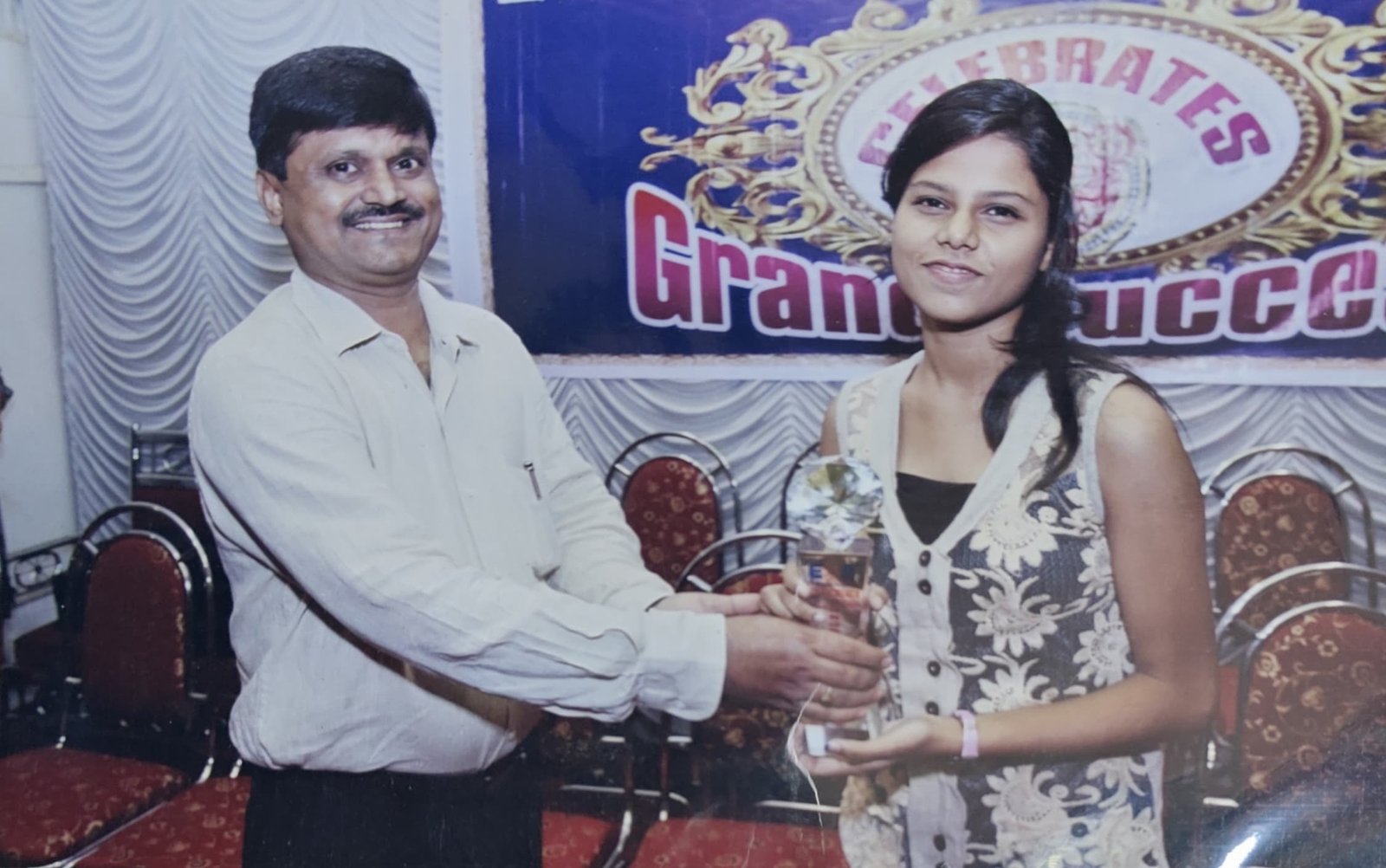 A topper receives her trophy on stage